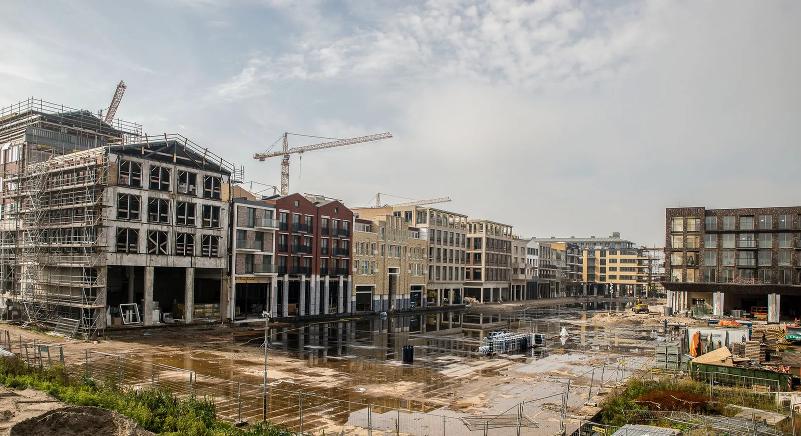 Grande obra de estrutura de concreto em andamento, com guindaste