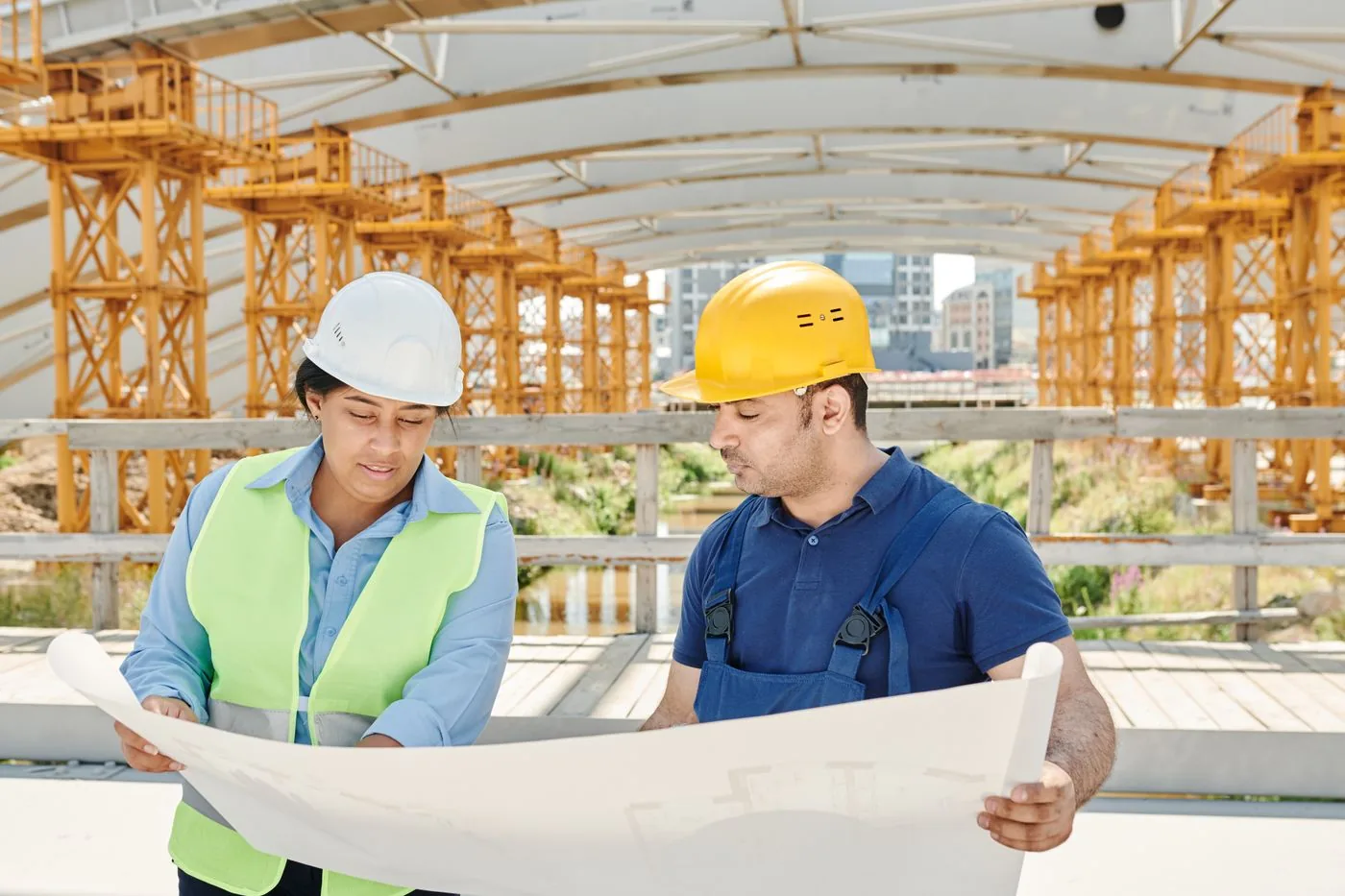 Engenheiros conferindo o projeto estrutural no canteiro de obra